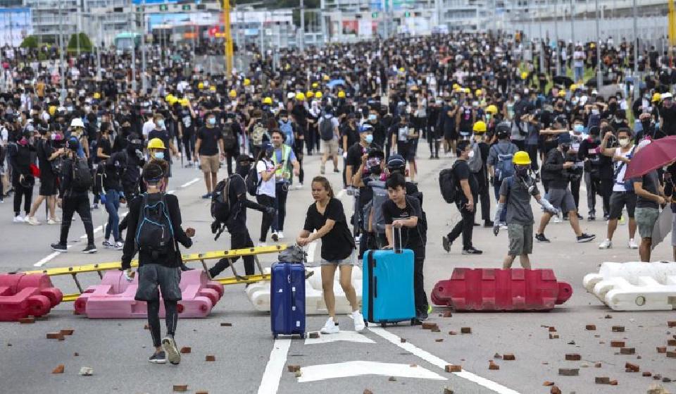 ผู้คนและนักท่องเที่ยวต้องลากกระเป๋าเดินตามถนนเพื่อไปยังสนามบิน ภาพโดย Dickson Lee/scmp