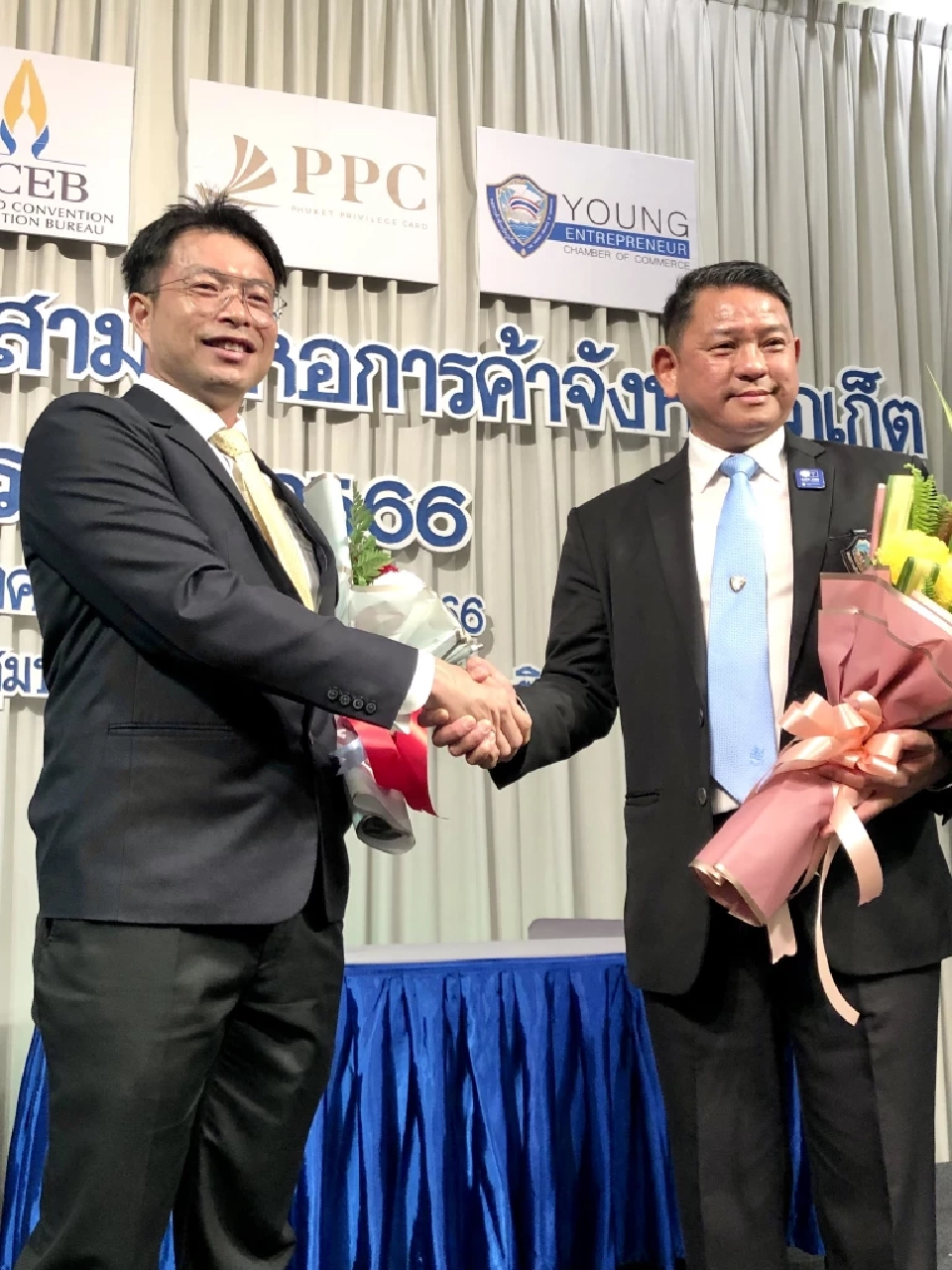 นายธนูศักดิ์ พึ่งเดช ประธานหอการค้าภูเก็ต ชุดเก่า มอบดอกไม้แสดงความยินดีนายก้องศักดิ์ คู่พงศกร ประธานกรรมการหอการค้าภูเก็ค คนใหม่