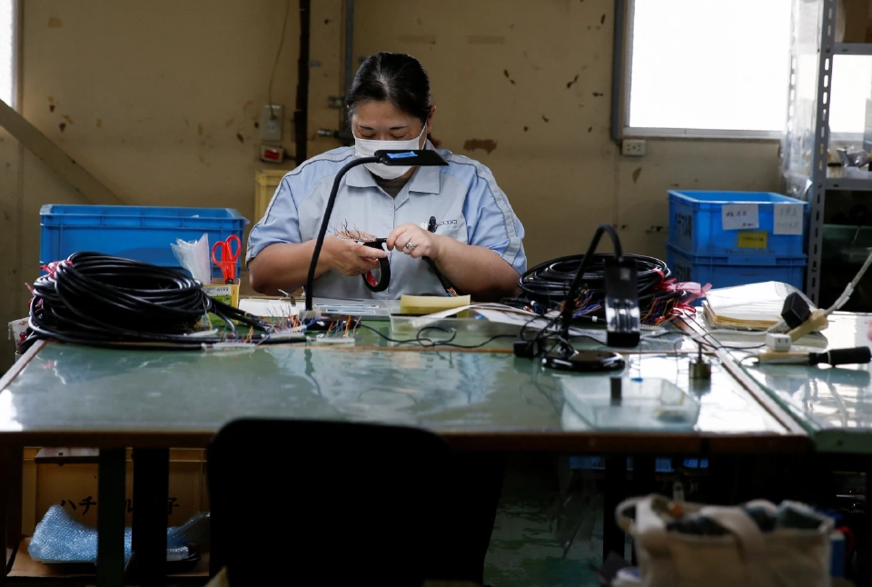 คนงานกำลังประกอบสายไฟที่โรงงานของฮาจิมารุในมากิโนะฮาระ 