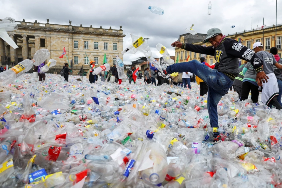 คนกำลังเตะขวดพลาสติกในขณะที่บริษัทรีไซเคิลกำลังทิ้งวัสดุรีไซเคิลใน Plaza de Bolivar เพื่อประท้วงราคาวัสดุรีไซเคิลที่ลดลง ในโบโกตา โคลอมเบีย 24 มิถุนายน 2025 REUTERS
