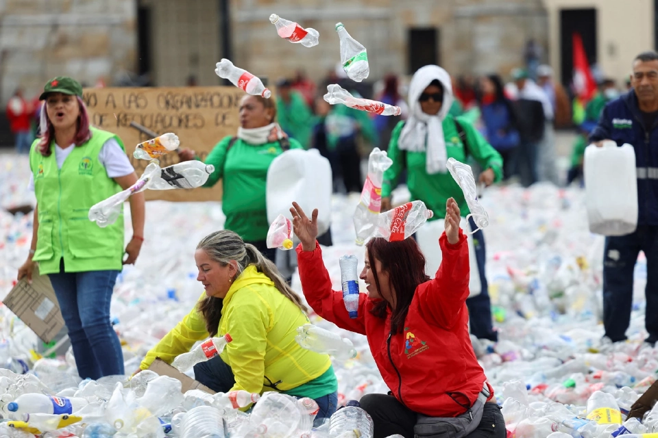 ผู้รีไซเคิลโยนขวดพลาสติกขึ้นไปในอากาศขณะที่ทิ้งวัสดุรีไซเคิลใน Plaza de Bolivar เพื่อประท้วงราคาวัสดุรีไซเคิลที่ลดลง ในโบโกตา โคลอมเบีย 24 มิถุนายน 2025 REUTERS
