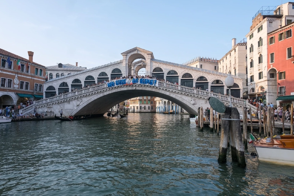 ผู้ประท้วงถือป้ายแบนเนอร์ที่มีข้อความว่า &quot;ไม่มีพื้นที่สำหรับเบโซส !&quot; บนสะพานรีอัลโตระหว่างการประท้วงการแต่งงานของเจฟฟ์เบโซส ผู้ก่อตั้ง Amazon กับลอเรน ซานเชซ ที่กำลังจะเกิดขึ้นในเวนิส อิตาลี เมื่อวันที่ 13 มิถุนายน 2025 REUTERS