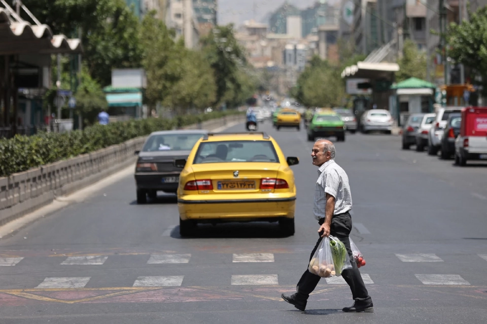 ชายคนหนึ่งกำลังเดินอยู่บนถนนท่ามกลาง ความขัดแย้งระหว่าง อิหร่านและอิสราเอลในกรุงเตหะราน