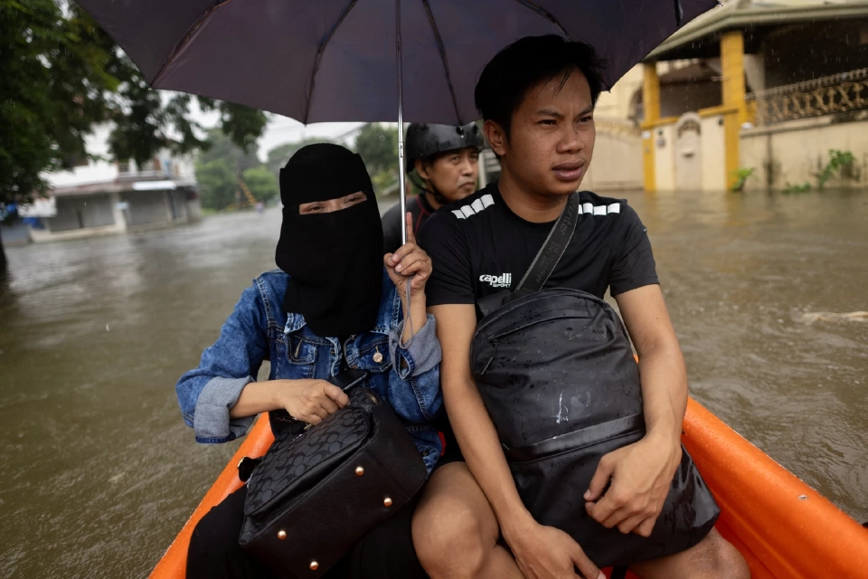 ประชาชนอพยพออกจากหมู่บ้านที่ถูกน้ำท่วมหลังจากฝนตกหนักในช่วงมรสุมในเมืองเคนตา จังหวัดรีซัล ประเทศฟิลิปปินส์ เมื่อวันที่ 22 กรกฎาคม 2568 REUTERS