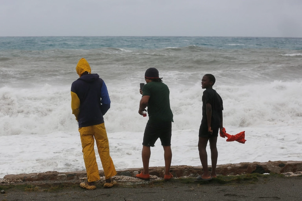 ผู้คนเฝ้าดูคลื่นซัดฝั่งขณะที่พายุเฮอริเคนเมลิสซากำลังเข้าใกล้ ในย่านฮาร์เบอร์วิว เมืองคิงส์ตัน ประเทศจาเมกา เมื่อวันที่ 27 ตุลาคม 2568 ภาพโดย REUTERS