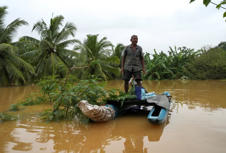 ชายคนหนึ่งยืนอยู่บนเรือในพื้นที่ที่ได้รับผลกระทบจากน้ำท่วม หลังจากฝนตกหนักในมัลวานา ศรีลังกา เมื่อวันที่ 29 พฤศจิกายน 2568 REUTERS