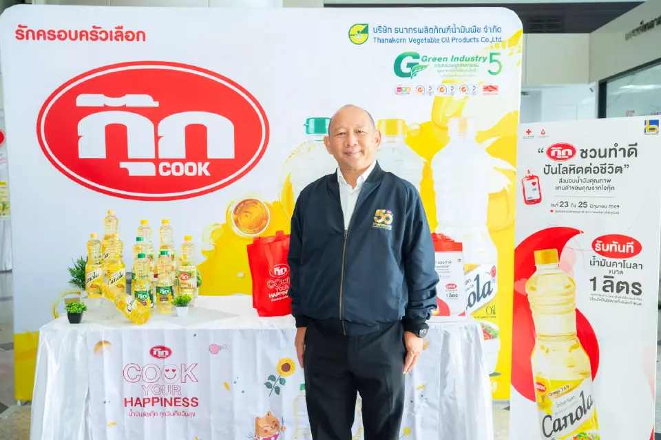 ผู้บริหารกุ๊กยืนหน้าบูธแบรนด์ COOK พร้อมผลิตภัณฑ์น้ำมันพืชหลากหลายขนาด ธนากรผลิตภัณฑ์น้ำมันพืช ตอกย้ำมาตรฐาน Green Industry ระดับ 5 ชูแคมเปญ "Cook Your Happiness" น้ำมันพืชกุ๊กปลอดภัยจากไขมันทรานส์