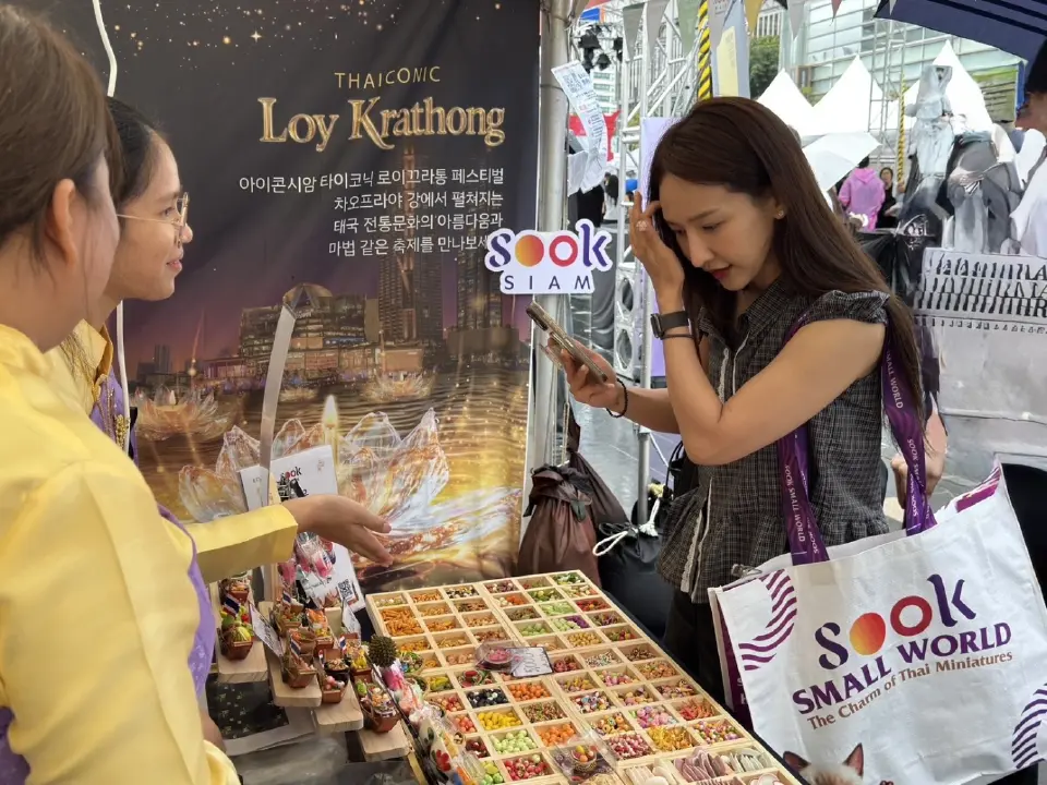 นักท่องเที่ยวชาวเกาหลีสนใจชมและถ่ายภาพของจิ๋วฝีมือช่างไทยจากร้านเล็กปั้นจิ๋ว เมืองสุขสยาม ภายในงาน Sawasdee Seoul 2026